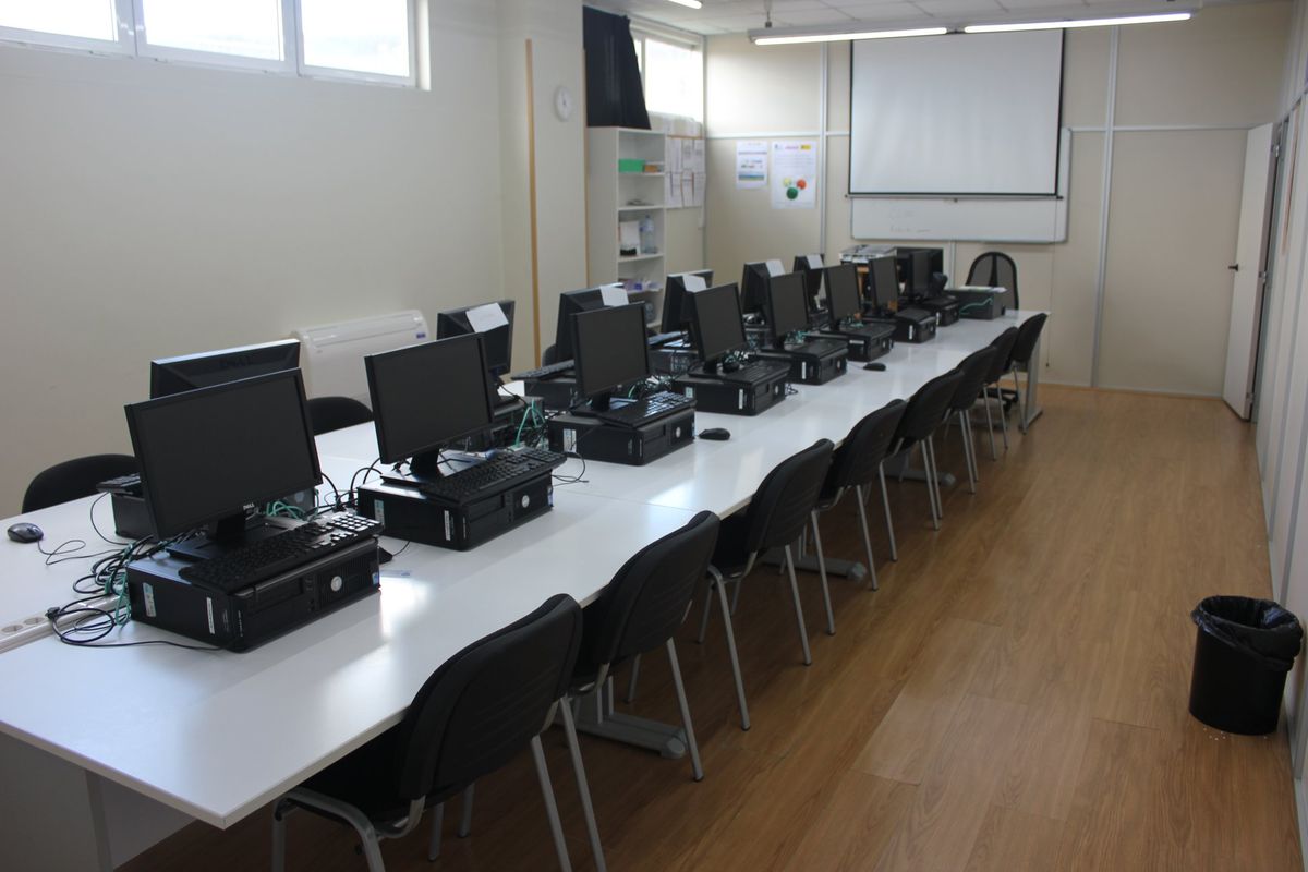 Aula de informática del Centro de Formación Piélagos con ordenadores y proyector